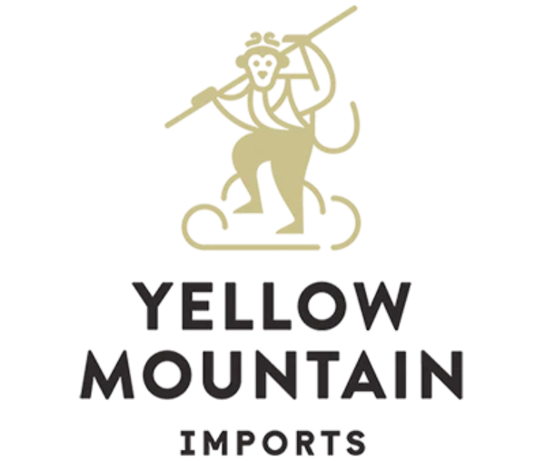 Logo of Yellow Mountain Imports with a stylized monkey design on a white background